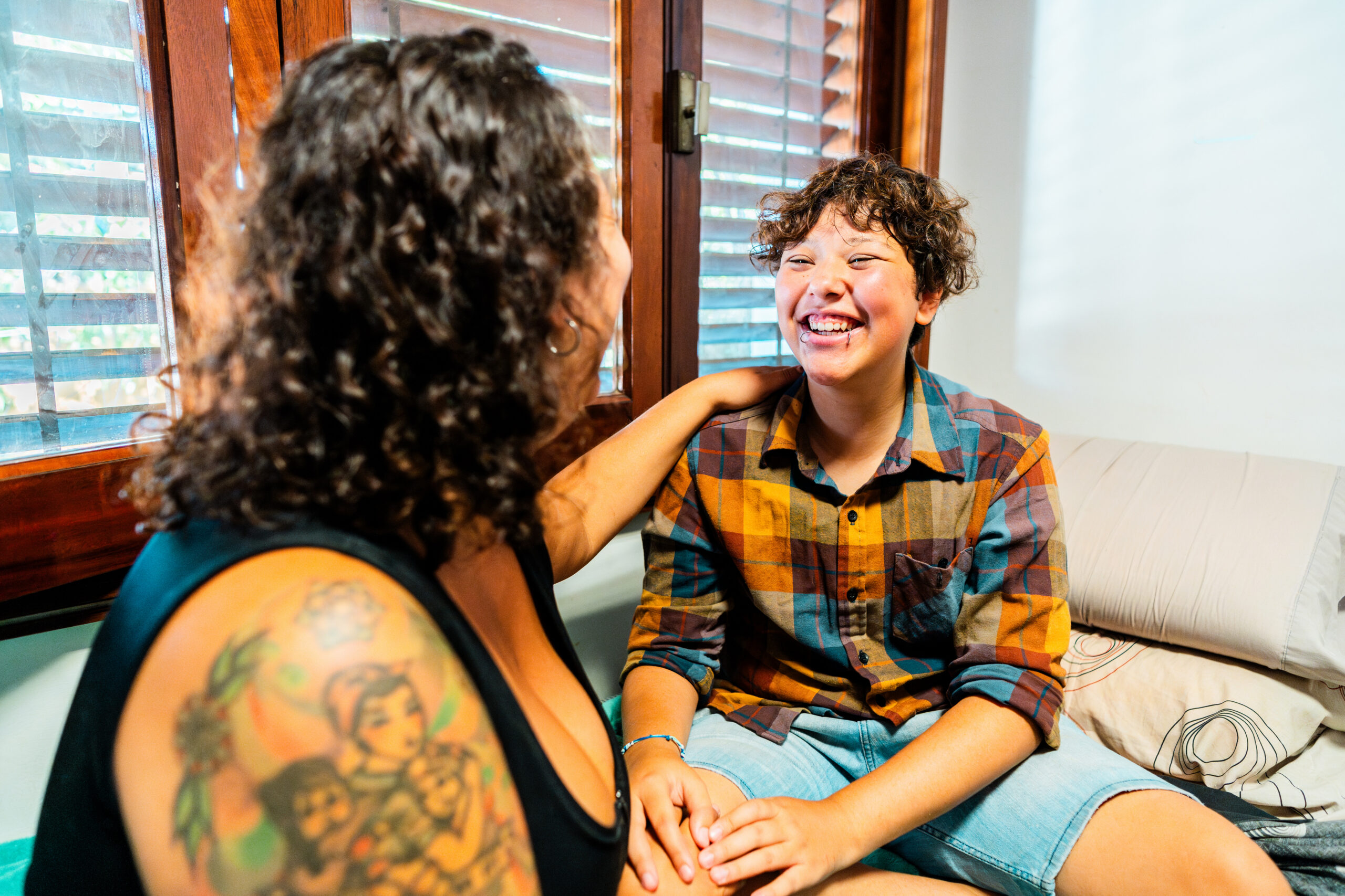 Transgender male talking with foster carer at home